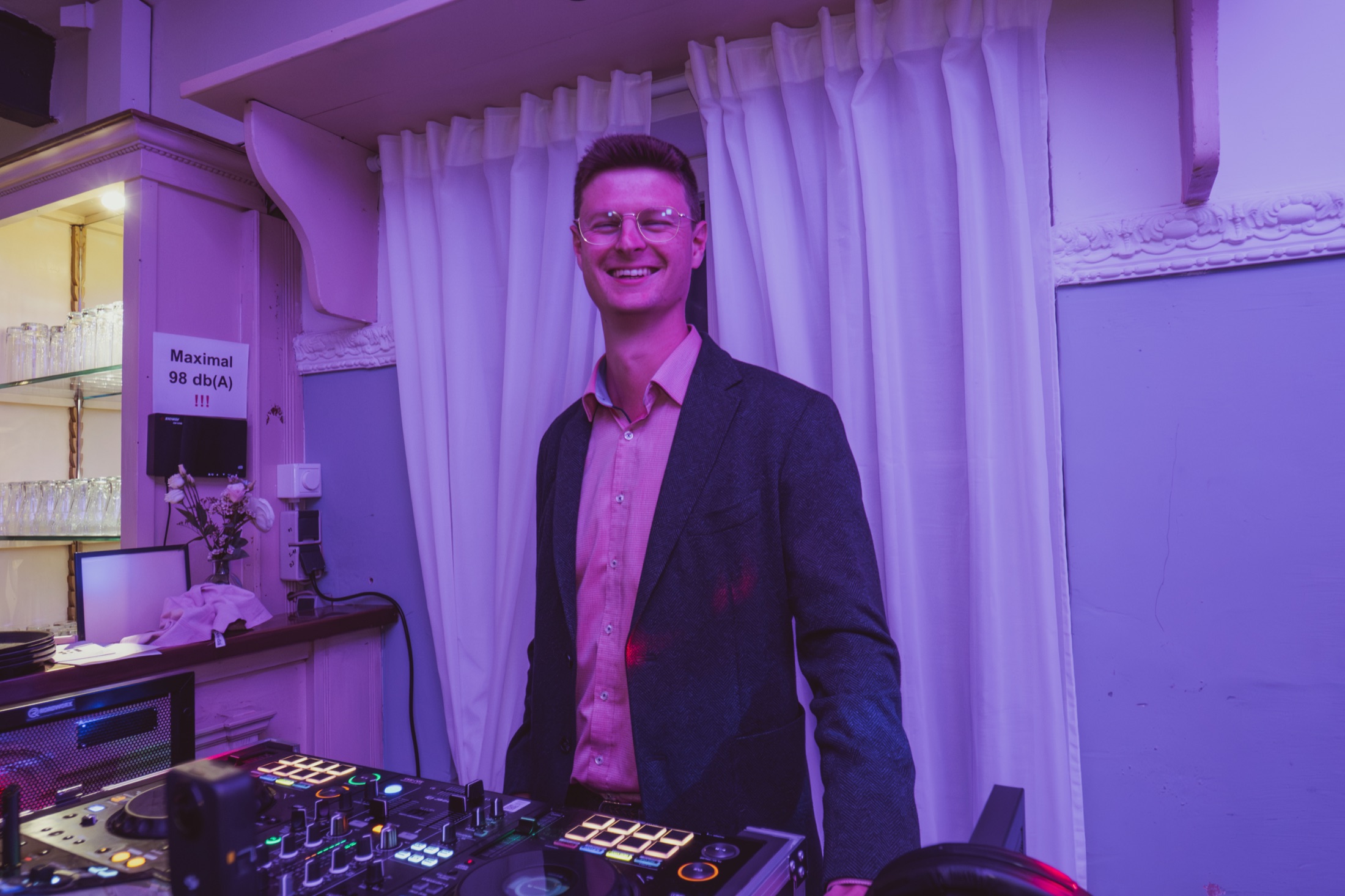 Stefan Nöken lächelnd hinter seinem DJ-Pult